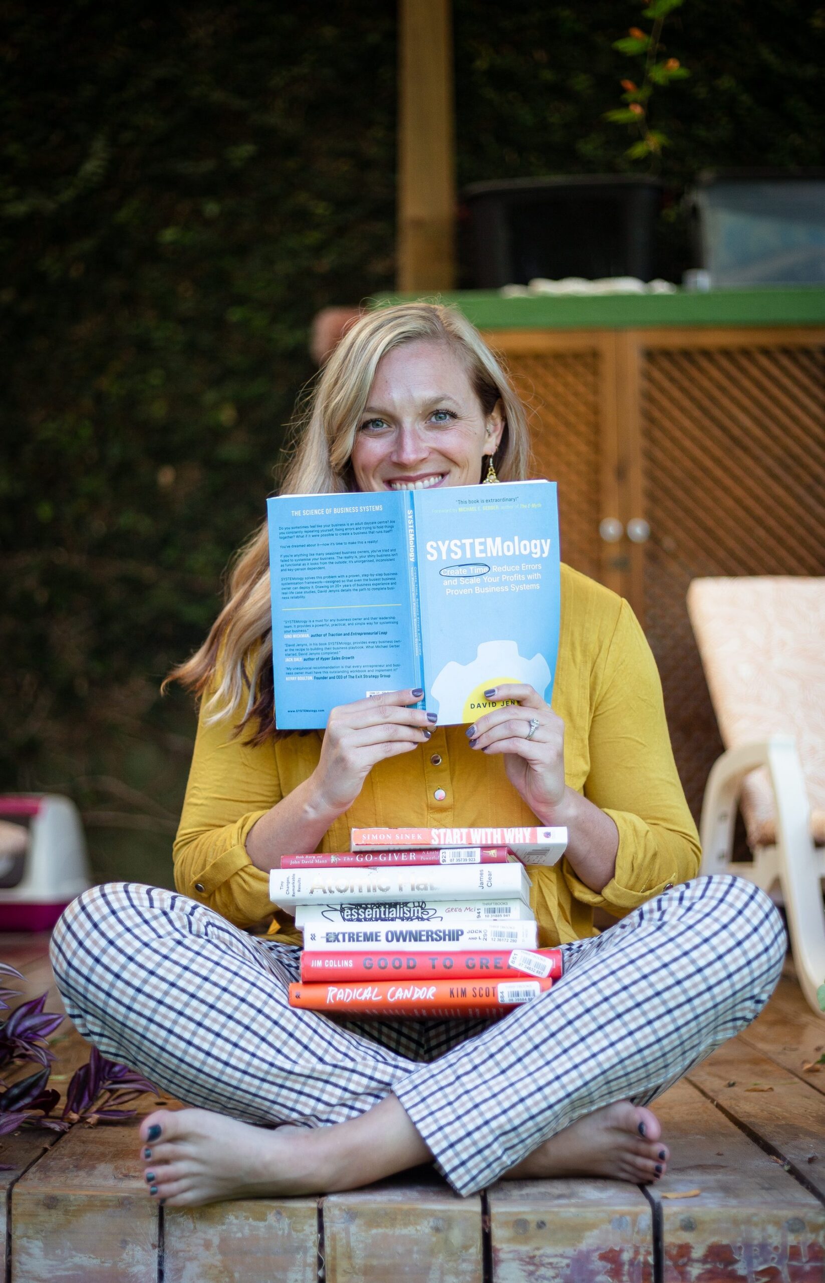 Ashley Weigl with a stack of business books